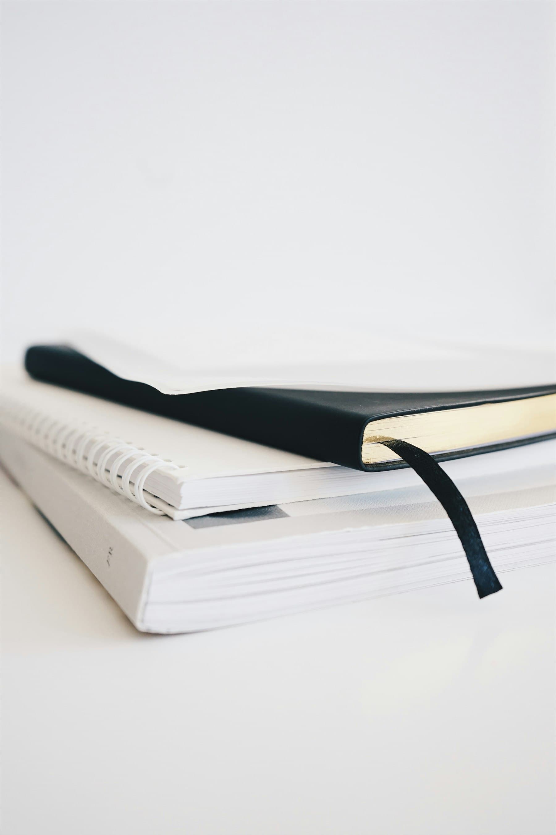 A stack of closed notebooks with visible spiral and bound spines